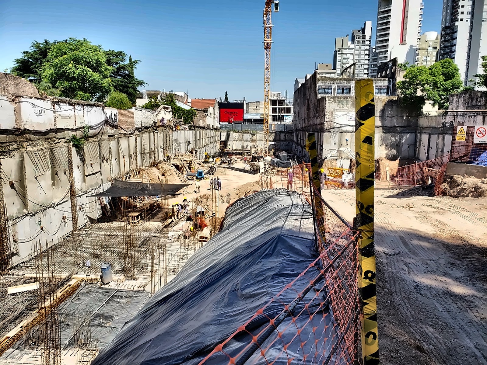Vista panorámica de obra urbana con torre grúa y control freático perimetral